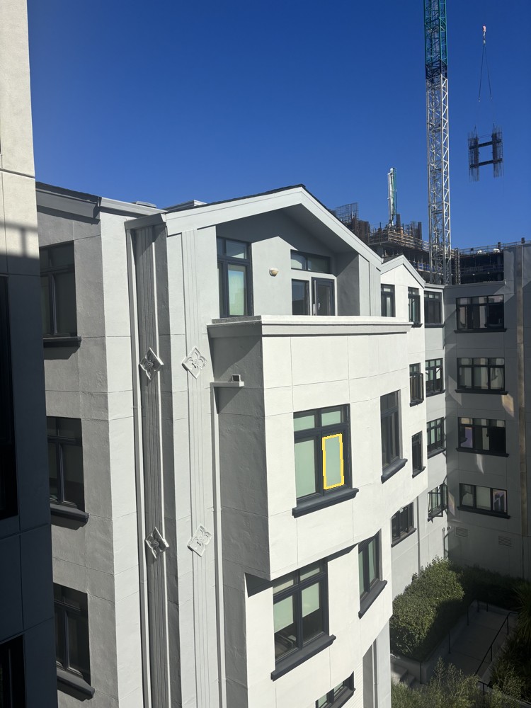 Courtyard photograph with selected window pane outlined in yellow